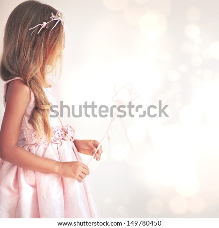 Beautiful little girl wearing fairy costume with magic wand