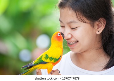 Beautiful Little Parrot Birds Standing On Woman Hand. Asian Teenager Girl Play With Her Pet Parrot Bird With Fun And Love