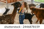 beautiful little red headed girl petting and feeding a goat in a petting zoo at the nezperce county fair in lewiston idaho