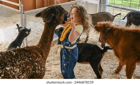 beautiful little red headed girl petting and feeding a goat in a petting zoo at the nezperce county fair in lewiston idaho - Powered by Shutterstock