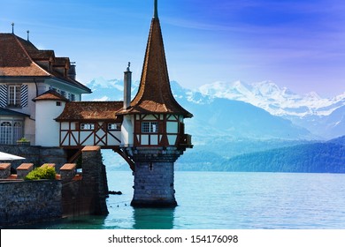 Beautiful little tower of Oberhofen castle in the Thun lake with mountains on background in Switzerland, near Bern 