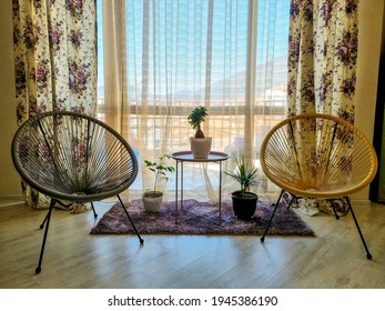 Beautiful Living Room Interior With Hardwood Floors And Modern Wire Chairs In New Luxury Home. Large Bank Of Windows Hints At Exterior View. 