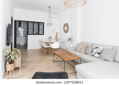 A Beautiful living room interior in new luxury home with open concept floor plan. Shows kitchen, dining room, and wall of windows with amazing exterior - Powered by Shutterstock