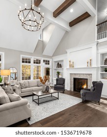 Beautiful Living Room In New Traditional Style Luxury Home. Features Vaulted Ceilings, Fireplace With Roaring Fire, And Elegant Furnishings.