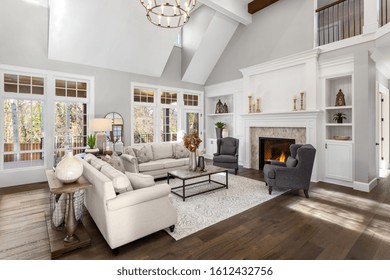 Beautiful Living Room In New Traditional Style Luxury Home. Features Vaulted Ceilings, Fireplace With Roaring Fire, And Elegant Furnishings.