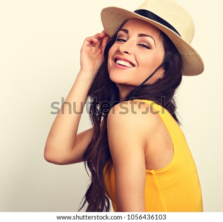 Beautiful long hair laughing woman in yellow top and straw hat looking happy with toothy smiling.Toned closeup vintage portrait