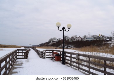 Beautiful long wooden promenade on the nature on the lake in winter