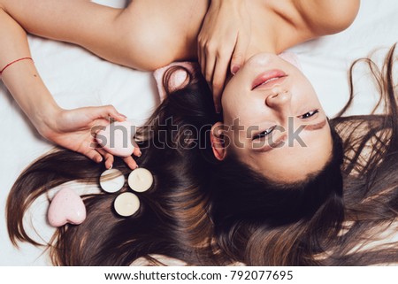 beautiful long-haired girl enjoying a spa, relaxing, scented candles