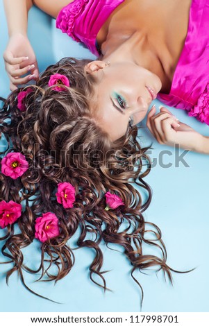 beautiful long-haired girl relaxing in her hair flowers