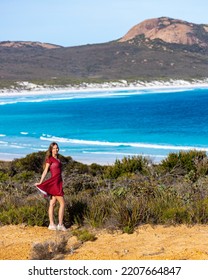 a beautiful long-haired girl stands on a hill overlooking a wonderful paradise beach with turquoise water and white sand. The famous lucky bay beach near esperance in western australia, cape le grand  - Shutterstock ID 2207664847
