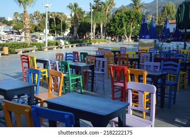 Beautiful Lots Of Colorful Wooden Chairs Of A Restaurant With Tables, Empty Chairs And Tables, No People, Painted Chairs Kas Harbour, Antalya Turkey, June 2022.