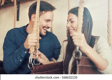 Beautiful loving couple relaxing in swing while talking and flirting. Love and tenderness, romance, dating, relationships  - Shutterstock ID 568632133