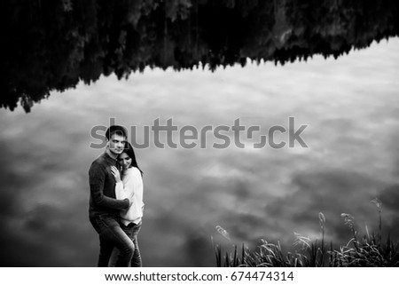 Beautiful loving couple standing by the lake outdoors
