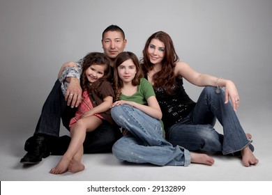 Beautiful Loving Family of 4 on Grey Background