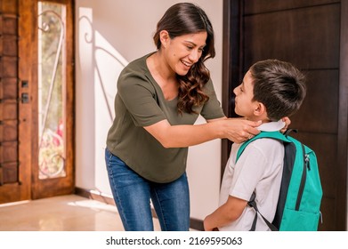 Beautiful loving  Latin mother with her children at the door of her house. Mother greets her children who return from school. Children with uniforms and backpacks. - Shutterstock ID 2169595063