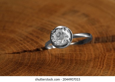 Beautiful luxury engagement ring with gemstone on tree stump, closeup - Shutterstock ID 2044907015