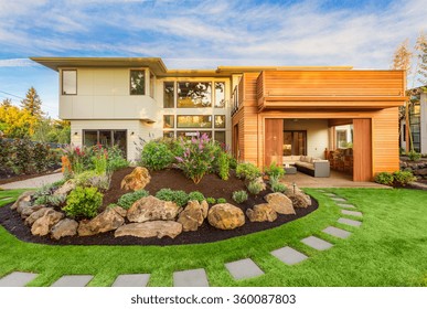 Beautiful Luxury Home Exterior  With Balcony And Green Grass On Sunny Afternoon