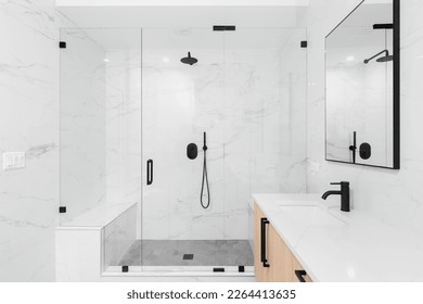 A beautiful luxury, modern bathroom with a light wood cabinet, walk-in shower with marble tiled walls, and black faucets and hardware.