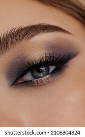 Beautiful macro shot of female eye make-up in smoky eyes style. Blue eye. Creative make-up. Perfect shape make-up and long lashes. Cosmetics. Beautiful eyes make-up. Close-up - Shutterstock ID 2106804824