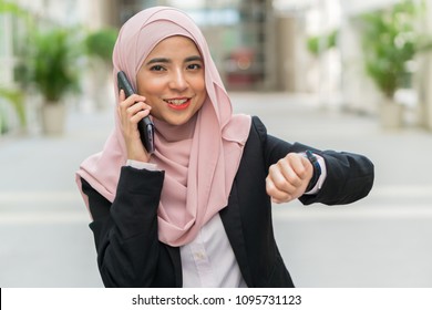 Beautiful Malay Girl Holding Mobile Phone Outdoor Looking At The Watch