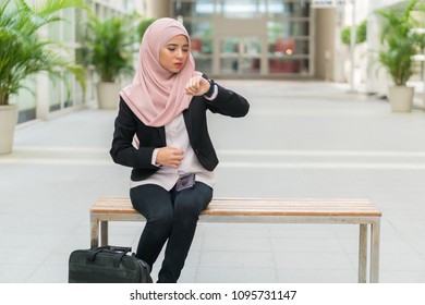 Beautiful Malay Girl Holding Mobile Phone Outdoor Looking At The Watch