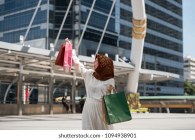 Beautiful malaysia young woman a smiling and happy with shopping bags,  lifestyle concept in the big city, the business district with skyscrapers in the Background - Shutterstock ID 1094938901