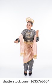 A beautiful Malaysian traditional female dancer performing a cultural dance routine called Tarian Joget in a traditional dance outfit. Full length isolated in white.
