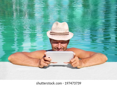 beautiful man by the pool with a tablet - Powered by Shutterstock