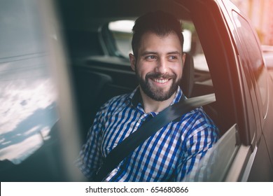 Beautiful Man Smiling While Sitting On Back Seat In The Car