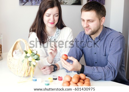 beautiful man and woman paint eggs at home.family, love, cooking Easter concept