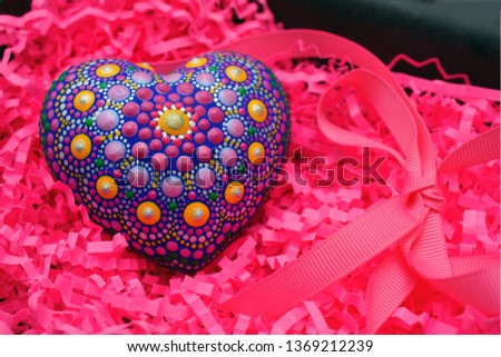 Beautiful mandala hand painted on plaster heart on fuchsia background