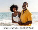 Beautiful mature black couple of lovers dating at the seaside - Married african middle-aged couple bonding and having fun outdoors, concepts about relationship, lifestyle and quality of life