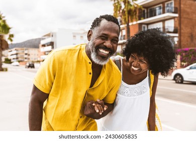 Beautiful mature black couple of lovers dating at the seaside - Married african middle-aged couple bonding and having fun outdoors, concepts about relationship, lifestyle and quality of life - Powered by Shutterstock