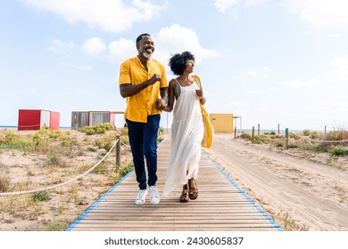 Beautiful mature black couple of lovers dating at the seaside - Married african middle-aged couple bonding and having fun outdoors, concepts about relationship, lifestyle and quality of life - Powered by Shutterstock