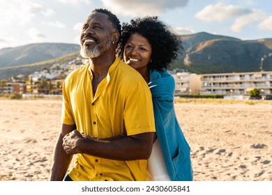 Beautiful mature black couple of lovers dating at the seaside - Married african middle-aged couple bonding and having fun outdoors, concepts about relationship, lifestyle and quality of life - Powered by Shutterstock