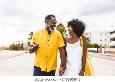 Beautiful mature black couple of lovers dating at the seaside - Married african middle-aged couple bonding and having fun outdoors, concepts about relationship, lifestyle and quality of life - Powered by Shutterstock