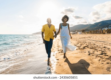 Beautiful mature black couple of lovers dating at the seaside - Married african middle-aged couple bonding and having fun outdoors, concepts about relationship, lifestyle and quality of life - Powered by Shutterstock