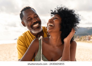 Beautiful mature black couple of lovers dating at the seaside - Married african middle-aged couple bonding and having fun outdoors, concepts about relationship, lifestyle and quality of life - Powered by Shutterstock