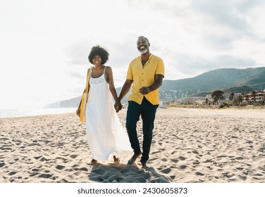 Beautiful mature black couple of lovers dating at the seaside - Married african middle-aged couple bonding and having fun outdoors, concepts about relationship, lifestyle and quality of life - Powered by Shutterstock