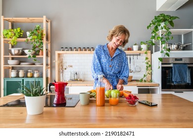 Beautiful mature senior woman at home, domestic life and leisure moments - 50-60 years old pretty female adult cooking healthy food at home in the kitchen for diet - Powered by Shutterstock