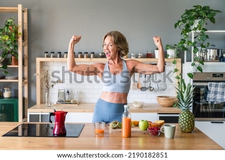 Beautiful mature senior woman at home, domestic life and leisure moments - 50-60 years old pretty female adult wearing sportswear eating healthy food after fitness workout