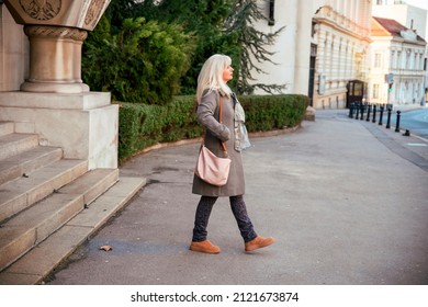 Beautiful Mature Stylish Woman With White Long Hair Walking In The City Street. Copy Space 