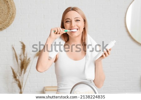 Beautiful mature woman  brushing teeth in bathroom