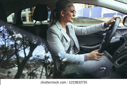 Beautiful Mature Woman In Business Suit Driving A Car To Office. Businesswoman Drive A Car In City.