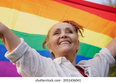 Beautiful Mature Woman With Charming Smile Holding Rainbow LGBT Flag In Her Hands, Gay And Lesbian Rights Concept For All Ages