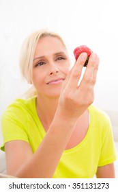 A Beautiful Mature Woman Eating Strawberry At Home.
