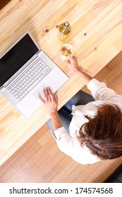 A Beautiful Mature Woman With A Glass Of White Wine In Front Of The Laptop.