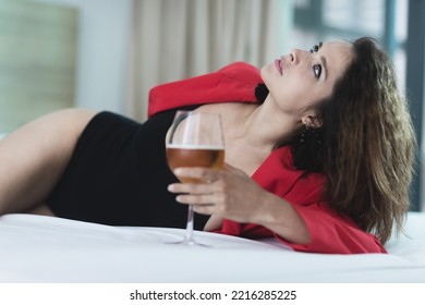 Beautiful Mature Woman Laying In Bed With A Glass Of Wine