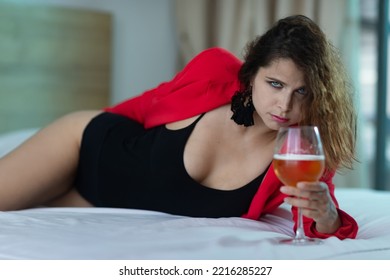 Beautiful Mature Woman Laying In Bed With A Glass Of Wine