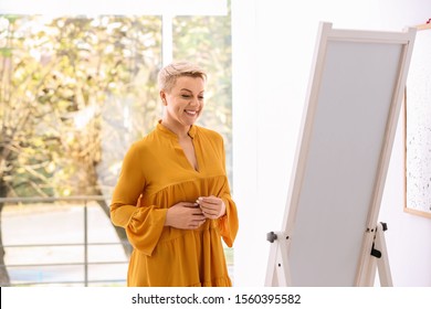 Beautiful Mature Woman Looking At Herself In Large Mirror Indoors